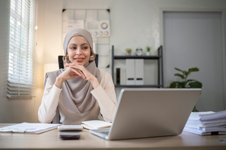 Attractive Muslim accounting business woman working using laptop in modern office